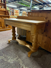 Load image into Gallery viewer, An elegant Victorian pine washstand that brings authentic period character to any interior. Structurally sound with a beautiful aged patina and minor surface marks that enhance its vintage charm. The single front drawer provides practical storage, while its versatile design works equally well as a bathroom vanity, hallway table, or decorative accent piece. A timeless addition for those who appreciate genuine period furniture.
Delivery Available
Overall Dimensions
105cm wide x 45cm deep x 73cm / 82cm high