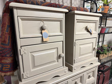 Load image into Gallery viewer, A charming pair of pine bedsides finished in Farrow & Ball's soft 'String' with a gently distressed aesthetic. Each unit features solid construction, one drawer, and one cupboard—providing practical storage for bedside essentials. Characterful and versatile, they bring warmth and vintage appeal to any bedroom setting.
Delivery Available
Overall Dimensions
45cm wide x 40cm deep x 61cm high