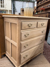 Load image into Gallery viewer, A beautiful stripped oak chest of drawers, restored to reveal its natural grain and character. Structurally sound with excellent storage capacity across two short dovetail-jointed drawers and three generous long drawers. The bare wood finish showcases authentic craftsmanship and may benefit from a protective wax coat to enhance durability and lustre.
Delivery Available
Overall Dimensions
76cm wide x 44cm deep x 79.5cm high