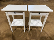 Load image into Gallery viewer, A pair of white IKEA bedside tables in solid working order. Each features a practical drawer and open shelf below, providing convenient storage for essentials. As pre-owned pieces, they show minor cosmetic wear consistent with normal use, but remain structurally robust and fully functional. Ideal for anyone seeking affordable, space-saving bedroom furniture with genuine utility.
Delivery Available
Overall Dimensions
46cm wide x 35cm deep x 70cm high