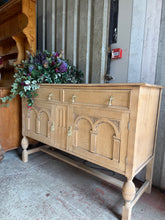 Load image into Gallery viewer, This oak sideboard showcases beautiful natural grain, freshly stripped back to reveal wood. The bare finish offers versatility—apply wax or oil to suit your décor and protect the surface. Generous storage combines two dovetail-jointed drawers with two spacious cupboards below, perfect for displaying tableware or concealing everyday items. Structurally sound and built to last, this piece brings warmth and timeless appeal to any dining room or hallway.
Delivery Available
Overall Dimensions
138cm wide x 50c