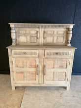 Load image into Gallery viewer, A characterful stripped chiffonier with authentic patina and natural wood finish. Features a cupboard in the section, two practical drawers, and a spacious double cupboard in the base—ideal for dining room storage. The bare wood shows honest wear marks that add vintage charm. A protective wax coat is recommended to enhance and preserve the finish.
Delivery Available
Overall Dimensions
122cm wide x 46cm deep x 126cm high
