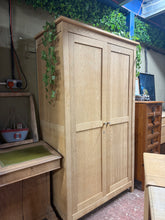 Load image into Gallery viewer, A characterful modern oak wardrobe, stripped back to reveal natural wood grain. Features one hanging rail and one shelf, offering flexible storage for clothes and accessories. Structurally sound with minor surface marks. The bare wood finish invites personalisation — a coat of wax or oil will enhance protection and deepen the natural patina. Ideal for those seeking sustainable, vintage-inspired furniture with genuine character.
Delivery Available
Overall Dimensions
105cm wide x 56cm deep x 184.5cm high