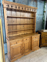 Load image into Gallery viewer, The Vintage Pine Dresser is a charming and sturdy piece that brings warmth and character to any room. Despite being used, it remains structurally sound, with natural marks that enhance its vintage appeal. This dresser offers generous storage options, featuring three shelves in the upper section, three spacious drawers, and three cupboards at the base—perfect for organising linens, or household essentials. Its timeless design and functional layout make it a delightful addition to your home, combining practic