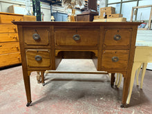 Load image into Gallery viewer, A handsome Edwardian mahogany desk combining period charm with practical functionality. Featuring solid construction with five dovetail-jointed drawers—four compact and one full-width—offering generous storage for documents and desk essentials. The rich mahogany patina displays marks befitting its age and use. Includes original key. An elegant addition to home offices, studies, or period interiors seeking vintage craftsmanship and timeless appeal.
Delivery Available
Overall Dimensions
107cm wide x 49.5cm