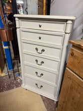 Load image into Gallery viewer, Discover the timeless elegance of this Laura Ashley Clifton tallboy in classic ivory. A well-loved piece with character, it showcases the quality craftsmanship Laura Ashley is renowned for. Featuring six generous drawers, it offers excellent storage solutions for any bedroom. While it bears the gentle patina of use with some surface marks, particularly on top, the piece remains structurally robust and ready to bring sophisticated style to your home.
Overall Dimensions
59.5cm wide x 37cm deep x 109cm high