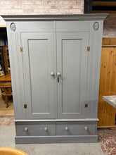Load image into Gallery viewer, This charming solid pine wardrobe has been painted grey by its previous owners and might need a little freshening up or a new coat of paint. It features one long hanging rail along with two short drawers crafted with dovetail joints for extra storage. Designed to come apart into four pieces for easy transport, it also includes its original key for added convenience.
Overall Dimensions
145cm wide x 56cm deep x 198.5cm high
DELIVERY AVAILABLE
For our other items see our website https://fossewayfurni