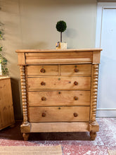 Load image into Gallery viewer, Discover the timeless appeal of this authentic Scottish pine chest of drawers, a versatile storage solution with genuine charm. Five generously proportioned drawers—including two dovetail-jointed short drawers and three long drawers—offer ample space for clothing, linens, or treasured items. A concealed secret drawer adds an element of surprise and nostalgia. Built to last, this well-maintained piece shows its age gracefully with minor patina that enhances its character. Ideal for traditional, rustic, or ec