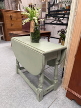 Load image into Gallery viewer, A charming small drop leaf table with practical folding sides, ideal for compact spaces. Finished in soft sage green with subtle distressing for vintage character. Structurally sound and in excellent condition, this versatile piece works beautifully in living rooms, dining areas, or as a stylish accent table. The drop leaf design allows you to expand when needed or keep it neat and tucked away. A timeless addition to any home.
Delivery Available
Overall Dimensions
61cm wide x 26cm deep x 50cm high 