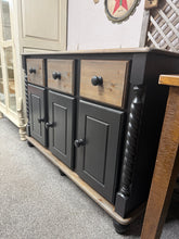Load image into Gallery viewer, A striking solid pine sideboard that combines rustic charm with contemporary style. Hand-finished in black with a black wash across the top, drawer fronts and plinth, creating an authentic vintage aesthetic. Features three dovetail-jointed drawers above single and double cupboards, offering generous storage for dining rooms, hallways or living spaces. The contrasting black wash and sanded surfaces add depth and character, making this a bold focal point for any interior.
Delivery Available
Overall Dimensio