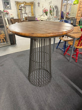Load image into Gallery viewer, A robust metal bar table that combines practicality with industrial appeal. This pre-loved piece shows authentic signs of use with light surface marks, yet remains solidly constructed and fully functional. Ideal for creating a casual dining spot in your kitchen or establishing an alfresco entertaining area. Its tall design makes it perfect for social gatherings, whether indoors or out.
Delivery Available
Overall Dimensions
91cm diameter x 102cm high