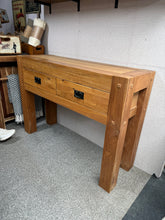Load image into Gallery viewer, A charming rustic oak console table with authentic character. Structurally sound and in good overall condition, this pre-loved piece bears gentle signs of use. Features two practical short drawers perfect for storing essentials. An ideal accent for hallways, living rooms, or entryways seeking warmth and vintage charm.
Delivery Available
Overall Dimensions
120cm wide x 40cm deep x 86cm high 