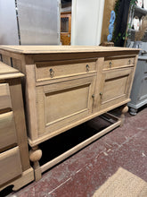 Load image into Gallery viewer, A beautiful stripped oak sideboard with authentic character. This piece has been returned to its natural wood finish and shows genuine signs of age and use, particularly on the top surface. A coat of quality wax will enhance the grain and provide protection while concealing minor marks. Features two dovetail-jointed drawers and two cupboards, offering practical storage with traditional craftsmanship. Perfect for those who appreciate vintage furniture with genuine patina.
Delivery Available
Overall Dimensi