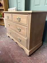 Load image into Gallery viewer, This elegant satinwood chest of drawers showcases beautiful natural grain, stripped back to reveal its authentic character. The piece features traditional dovetail joinery across four drawers—two shallow drawers positioned above two generous storage drawers—offering practical organisation with timeless appeal. The bare wood finish invites personalisation; a protective coat of wax will enhance the natural patina and safeguard the surface. A versatile addition to period or contemporary interiors, this chest c