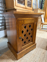 Load image into Gallery viewer, This beautiful hardwood side table features a charming lattice front and is solidly built. It shows some signs of use with minor marks, but nothing serious. Inside, you'll find a handy shelf for extra storage.
Overall Dimensions
51cm wide x 44cm deep x 67cm high
DELIVERY AVAILABLE
For our other items see our website https://fossewayfurniture.co.uk
collection from our shop at cv36, our collection zone at bs36 or otherwise delivery is available