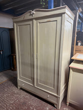 Load image into Gallery viewer, This charming antique pine wardrobe has been painted gloss white by its previous owners, featuring a lovely pink and blue top. Its attractive distressed finish makes it ideal for vintage lovers. It provides generous storage with a hanging rail and a long dovetail-jointed drawer. A minor repair inside one door has been made, but it doesn’t affect its function.
Overall Dimensions
125cm wide x 57cm deep x 188cm high
DELIVERY AVAILABLE
For our other items see our website https://fossewayfurniture.co.u