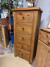 Load image into Gallery viewer, Discover the timeless appeal of this solid wooden tallboy with beautiful rustic planking that adds authentic charm to your space. Crafted with quality dovetail joinery, its five spacious drawers provide excellent storage solutions for any room. This sturdy piece is in wonderful condition with only minor cosmetic wear, making it a delightful find for those who appreciate character and craftsmanship.
Overall Dimensions
60cm wide x 43cm deep x 127cm high
DELIVERY AVAILABLE
For our other items see our