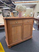 Load image into Gallery viewer, A beautiful stripped mahogany sideboard, restored to reveal its natural grain and warm patina. Features two dovetail-jointed drawers and a spacious double cupboard with internal shelf, offering generous storage for any room. Structurally sound with minor surface cracks that don't affect functionality. The bare wood finish invites personalisation—consider a protective wax coat to enhance colour and durability. A versatile piece that brings character and practical storage to hallways, dining rooms, or living