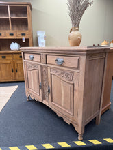 Load image into Gallery viewer, This beautifully stripped satinwood sideboard returns to its natural grain and warm patina. The piece features solid dovetail jointed drawers and a spacious double cupboard, offering plenty of storage for hallways, dining rooms, or living spaces. As a pre-loved item with authentic character, it may benefit from a protective coat of wax to enhance and preserve the wood. Light surface marks reflect its history and add to its vintage appeal. A versatile, quality piece ready to become part of your home.
Delive