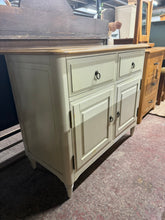 Load image into Gallery viewer, This charming country-style two tone sideboard is solidly built and in good overall shape. While it’s used and shows some minor marks, nothing stands out as significant. There is a small amount of discolouration here and there, but it’s barely visible. The sideboard features two dovetail jointed drawers above a double cupboard, providing plenty of storage space.
Overall Dimensions
98.5cm wide x 49cm deep x 83.5cm high
DELIVERY AVAILABLE
For our other items see our website https://fossewayfurniture