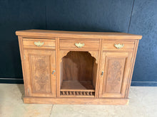 Load image into Gallery viewer, A beautiful stripped satinwood sideboard with authentic character and patina. Features three dovetail-jointed drawers positioned above two single cupboards and a cubby hole, offering versatile storage for any room. The natural finish showcases the wood's warm grain, though a protective coat of wax is recommended to enhance durability. Minor surface marks add to its vintage charm and do not impact functionality.
Delivery Available
Overall Dimensions
133cm wide x 45cm deep x 90cm high