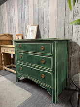Load image into Gallery viewer, This striking wooden chest of drawers combines timeless charm with practical storage. Painted in a rich forest green and finished with a subtle distressed effect, it showcases authentic craftsmanship and character. Featuring three spacious dovetail-jointed drawers, it offers reliable storage while serving as a sophisticated bedroom accent. Structurally sound and ready to enhance any space with vintage-inspired style.
Delivery Available
Overall Dimensions
91cm wide x 45cm deep x 81cm high