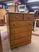 Load image into Gallery viewer, A characterful solid pine chest of drawers with authentic vintage appeal. Two short dovetail-jointed drawers sit above four generous long drawers, providing flexible storage for bedroom essentials or living spaces. Structurally sound with a honest patina — minor surface marks reflect its well-loved history rather than any compromise to durability or function. Ideal for those seeking genuine vintage furniture with practical storage and timeless design.
Delivery Available
Overall Dimensions
77cm wide x 40.