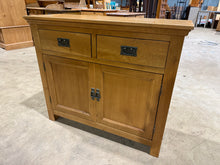 Load image into Gallery viewer, A sturdy modern oak sideboard built to last. Two dovetail-jointed drawers sit atop a double cupboard with a single shelf, offering flexible storage solutions for any room. The construction is solid and reliable, with minor cosmetic marks that add to its authentic appeal. A practical piece that combines functionality with understated style.
Delivery Available
Overall Dimensions
100cm wide x 35cm deep x 85cm high