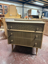 Load image into Gallery viewer, This vintage Uniflex chest of drawers has been stripped to bare wood, revealing its natural character and grain. The piece features three spacious dovetail-jointed drawers offering generous storage. Structurally sound in good conditon, it shows only minor cosmetic marks consistent with age. A protective wax finish would enhance the wood and provide lasting durability. An ideal choice for those seeking authentic retro furniture with genuine craftsmanship.
Delivery Available
Overall Dimensions
78.5cm wide