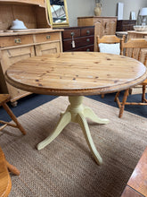 Load image into Gallery viewer, A charming solid pine round dining table with distinctive two-tone styling. The cream-painted legs offer classic appeal, while the pine top retains its original character with visible patina. The base would benefit from refreshing with a fresh coat of paint to restore its finish and the top could do with a sand and re-wax. Structurally sound and ready for your home, this table comfortably seats four and brings warmth and character to any dining space.
Delivery Available
Overall Dimensions
105cm diameter