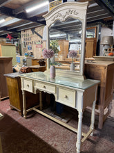 Load image into Gallery viewer, A cream dressing table with classic appeal and practical storage. Features a substantial removable mirror for convenient portability and three spacious drawers to keep your essentials organised. Structurally sound with a well-loved finish that reflects its character. The detachable mirror design makes moving and repositioning effortless, whilst the generous storage keeps your bedroom tidy and functional.
Delivery Available
Overall Dimensions
119cm wide x 45cm deep x 79cm to dressing table / 178cm to top