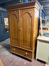Load image into Gallery viewer, A charming vintage pine wardrobe that's ready for a new home! This well-loved piece boasts solid construction and maintains its character beautifully despite its age. Featuring a practical hanging rail for your garments and a spacious dovetail-jointed drawer, it offers genuine storage solutions with authentic vintage appeal. The natural wear and patina only add to its rustic charm—perfect for those who appreciate furniture with history and personality.
Overall Dimensions
112cm wide x 59cm deep x 191cm hig