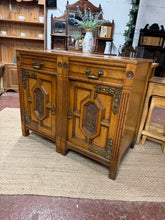 Load image into Gallery viewer, This beautiful Maple & Co sideboard is solidly built and generally in great condition. While it shows some signs of use, the marks are minor and do not detract from its charm. It offers plenty of storage space with two dovetail drawers and two cupboards—one featuring a shelf, and the other including a shelf plus a galvanised drawer designed to hold six bottles. It also comes with its two original keys for added convenience.
Overall Dimensions
109cm wide x 60.5cm deep x 90cm high
DELIVERY AVAILABLE