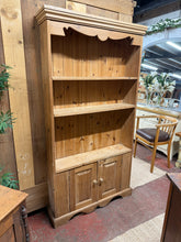 Load image into Gallery viewer, This solid pine bookcase is sturdy and in good condition overall. While it is pre-owned and shows some minor marks, they don’t detract from its charm. A hole was cut in the cupboard for wiring, but it doesn’t impact its functionality. Featuring two shelves and a double cupboard, it offers practical storage in a slim design—ideal for anyone needing space-saving solutions.
Overall Dimensions
95cm wide x 21cm deep x 179.5cm high
DELIVERY AVAILABLE
For our other items see our website https://fossewayf