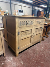 Load image into Gallery viewer, This beautiful oak sideboard has been stripped back to reveal its natural grain and warm patina. Featuring two dovetail-jointed drawers above a spacious double cupboard with internal shelf, it offers excellent storage versatility. The piece is structurally sound and ready to use, though a protective coat of wax will enhance the finish and durability. A timeless addition to any room.
Delivery Available
Overall Dimensions
107cm wide x 48cm deep x 86cm high 