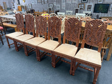 Load image into Gallery viewer, This stunning set of six Indian hardwood dining chairs features beautifully intricate carvings on each piece, adding a unique touch of craftsmanship to your dining area. All chairs are in overall good condition. While the seats are made from plywood, this design detail offers a great opportunity to customise with your preferred seat pads, enhancing both comfort and style to suit your décor.
Overall Dimensions
approx : 46cm wide x 47cm deep x 116cm high
DELIVERY AVAILABLE      
For our other items see ou