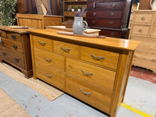 Load image into Gallery viewer, A handsome oak chest of drawers combining practical storage with timeless appeal. Seven dovetail-jointed drawers—three short and four long—offer generous space for bedroom essentials or living room organisation. The solid construction and classic proportions suit traditional and contemporary interiors alike. Shows minor surface marks consistent with vintage character. An enduring piece built to last.
Delivery Available
Overall Dimensions
138cm wide x 43cm deep x 77cm high 