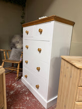 Load image into Gallery viewer, A charming solid pine chest of drawers with character. Features two short dovetail-jointed drawers above three spacious long drawers, offering generous storage for any bedroom or hallway. The piece is structurally sound and in good overall condition. Original paint shows patina from previous use—ideal for those seeking vintage appeal or a rewarding restoration project. The classic proportions and solid construction make it a versatile addition to country, farmhouse, or eclectic interiors.
Delivery Availabl