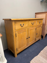 Load image into Gallery viewer, A characterful oak sideboard with authentic appeal. Structurally sound and in good overall condition, this piece bears the gentle patina of use with only minor surface marks. Features three dovetail-jointed drawers above three cupboards, offering generous storage for dining rooms or living spaces. A practical and attractive addition to period or eclectic interiors.
Delivery Available
Overall Dimensions
130cm wide x 40cm deep x 85cm high 