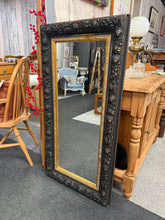 Load image into Gallery viewer, A stunning large black ornate mirror that's ready to make an impact in any room. Built to last with solid structural integrity, this piece combines timeless elegance with practical durability. While it bears the gentle patina of character, it's in excellent condition and will add sophisticated charm to your space.
Delivery Available
Overall Dimensions
56cm wide x 116cm high 