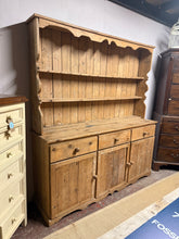Load image into Gallery viewer, This charming vintage pine dresser is solidly built and well-preserved for its age. It features some marks and a small missing panel on one door, adding to its unique character. The dresser includes three dovetail-jointed drawers above a double and a single cupboard, each with a shelf inside. The top offers two fixed shelves for extra storage. For convenience, it can be separated into two pieces to make moving easier.
Overall Dimensions
182cm wide x 47cm deep x 202.5cm high
DELIVERY AVAILABLE
For