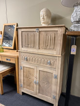 Load image into Gallery viewer, A distinctive oak drinks cabinet with authentic vintage character. This structurally sound piece features a drop-down top, single long drawer, and double cupboard storage — ideal for displaying glassware or spirits. Stripped to bare wood, it's ready for your choice of finish; a coat of wax will enhance the natural grain beautifully. Shows honest wear consistent with its age, with only minor marks that add to its period charm. A functional statement piece for any dining room or home bar.
Delivery Available
