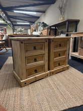 Load image into Gallery viewer, A beautiful pair of stripped pine bedside tables, restored to their natural wood finish. Each unit features three practical short drawers, ideal for storing bedside essentials. The bare wood may benefit from a protective wax coat to enhance durability and appearance. Perfect for adding warmth and character to any bedroom.
Delivery Available
Overall Dimensions
53cm wide x 39cm deep x 67cm high