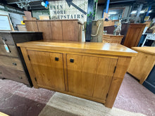 Load image into Gallery viewer, This beautiful solid wood sideboard is sturdy and generally in great shape. While it shows some signs of use with minor marks, they are hardly noticeable. Inside, there is a single shelf providing handy storage space. Although half of the back panel is missing, it doesn’t impact the sideboard’s functionality at all.
Overall Dimensions
134cm wide x 47cm deep x 81cm high
DELIVERY AVAILABLE      
For our other items see our website https://fossewayfurniture.co.uk
collection from our shop at cv36, our coll