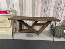 Load image into Gallery viewer, This charming rustic hall table combines timeless style with practical functionality. Crafted from solid wood and supported by elegant hairpin legs, it brings warmth and character to any hallway, living room, or entryway. The piece is structurally sound and in good overall condition, with minor surface marks that add to its authentic vintage appeal. A versatile statement piece that works beautifully in both traditional and contemporary interiors.
Delivery Available
Overall Dimensions
150cm wide x 44.5cm