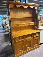 Load image into Gallery viewer, A charming solid pine dresser brimming with character and practicality. This well-loved piece boasts impressive storage with four drawers and two shelves in the upper section, complemented by three dovetail-jointed drawers below and convenient cupboard space. The honest patina tells a story of years of reliable service, whilst remaining structurally sound and ready for its next chapter. Designed with convenience in mind, it separates into two sections for effortless transport and repositioning.
Overall Dim