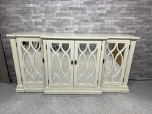 Load image into Gallery viewer, Discover the timeless elegance of this Art Deco sideboard, a versatile storage solution that combines vintage charm with practical functionality. Finished in a sophisticated off-white tone. Well-maintained and structurally robust, it features three spacious cupboards—two single and one double—each equipped with internal shelving to organise your belongings effortlessly. The natural patina from its pre-loved history adds authentic character.
Overall Dimensions
180.5cm wide x 46cm deep x 91cm high
DELIVERY