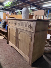 Load image into Gallery viewer, This beautiful stripped oak sideboard showcases the wood's natural grain and character. Featuring two dovetail-jointed drawers above a double cupboard with internal shelf, it offers practical storage with authentic craftsmanship. The piece is structurally sound and ready for use, though a protective coat of wax is recommended to enhance the finish. Minor veneer lifting on one side adds to its vintage charm and does not affect functionality. A timeless addition to any home.
Delivery Available
Overall Dimen
