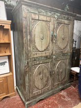 Load image into Gallery viewer, This exceptionally substantial cupboard showcases a captivating blue-green distressed finish that adds character and charm to any room. Featuring two shelves—one in the lower section and one above—it offers practical storage versatility. A convenient rear aperture accommodates wiring, making it ideal for concealing cables. Originally sourced from India then moved to dubai, this piece is ready for its next chapter. Well-suited as a linen press, larder, or display cabinet, it can be easily customised with add