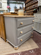 Load image into Gallery viewer, A solid pine chest of drawers with timeless appeal. Painted in Farrow & Ball's 'London Stone', this piece features natural wood top, knobs, and legs for warm contrast. Built with three deep dovetail-jointed drawers offering ample storage. Structurally sound with minor surface marks consistent with vintage character. Ideal for bedrooms, living spaces, or hallways.
Delivery Available
Overall Dimensions
86cm wide x 46cm deep x 79cm high